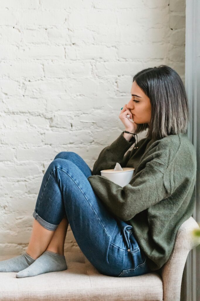 Una mujer en el sillón, con un paquete de pañuelos en la mano, siendo un proceso para reflexionar.