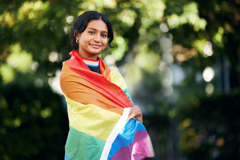 Una persona con la bandera de la comunidad LGBT+ siendo consciente de sus preferencias, emociones y necesidades.