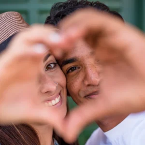 Hay dos personas que están haciendo un corazón con las manos, representan amor libre